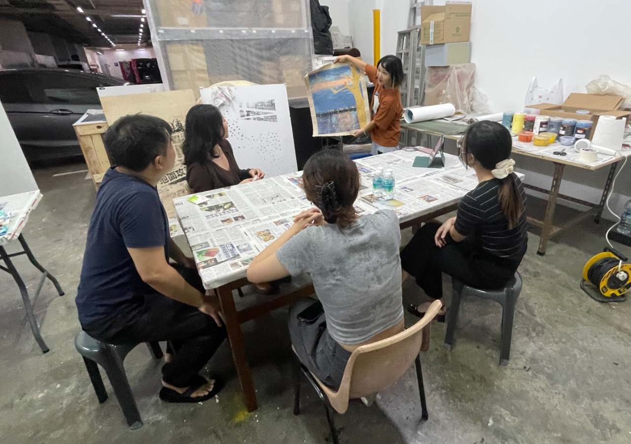 Participants engaging in a Conscious Maker's session at Ascend Makea, learning silkscreen printing techniques using custom-designed stencils and ink.